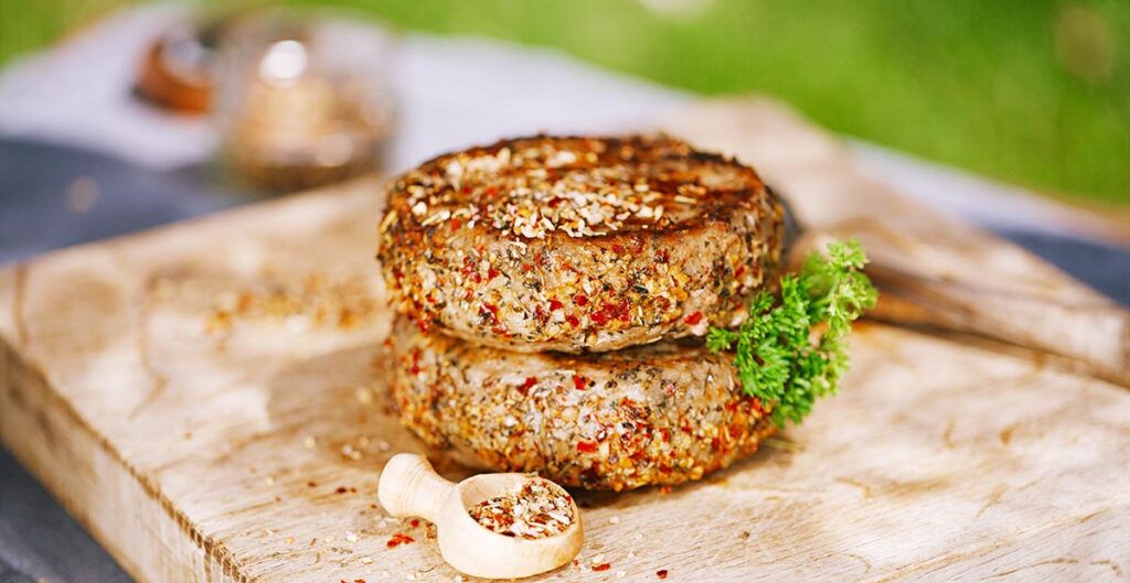 lamb burgers spiced by mint and lamb rub on wooded board